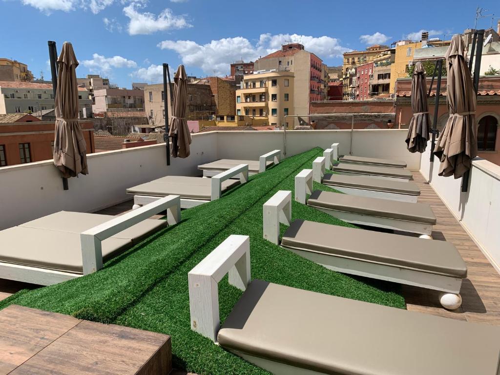a row of beds on the roof of a building at Neko Boutique Hotel in Cagliari