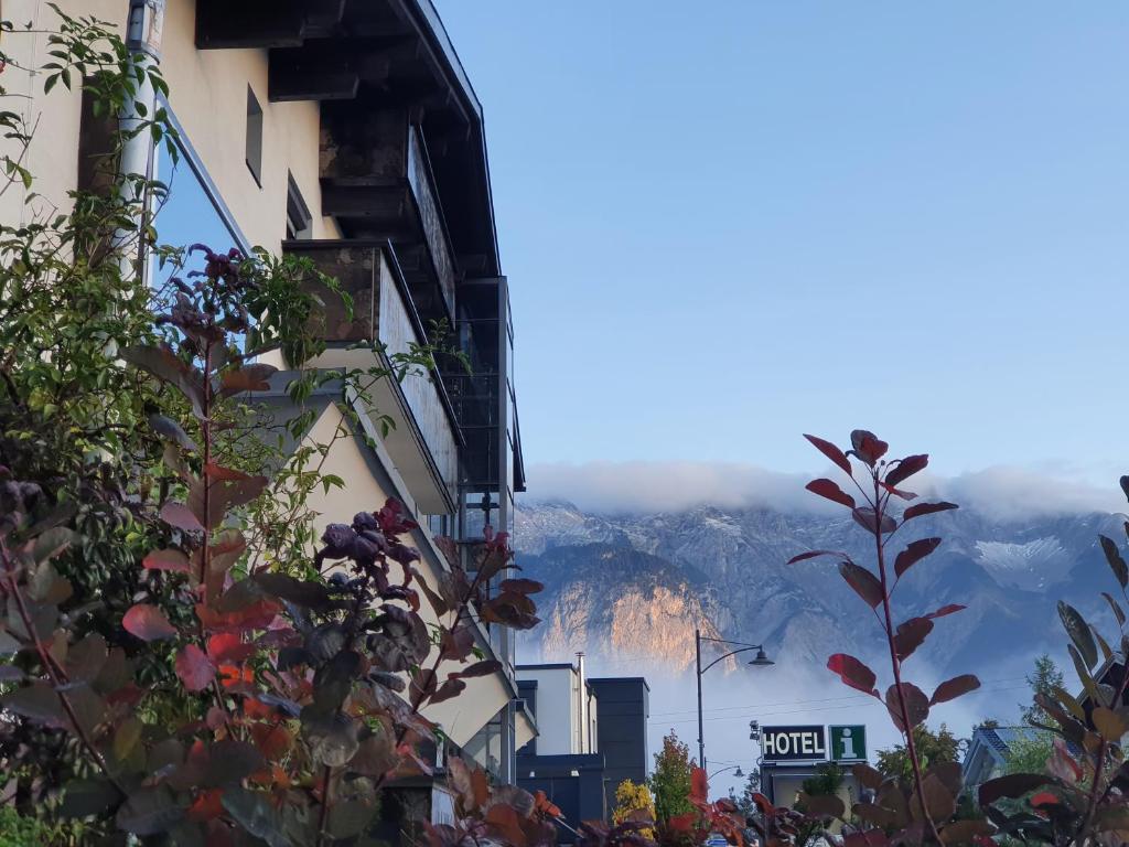 einen Blick auf die Berge von zwei Gebäuden in der Unterkunft Alp Art Hotel Götzens in Innsbruck