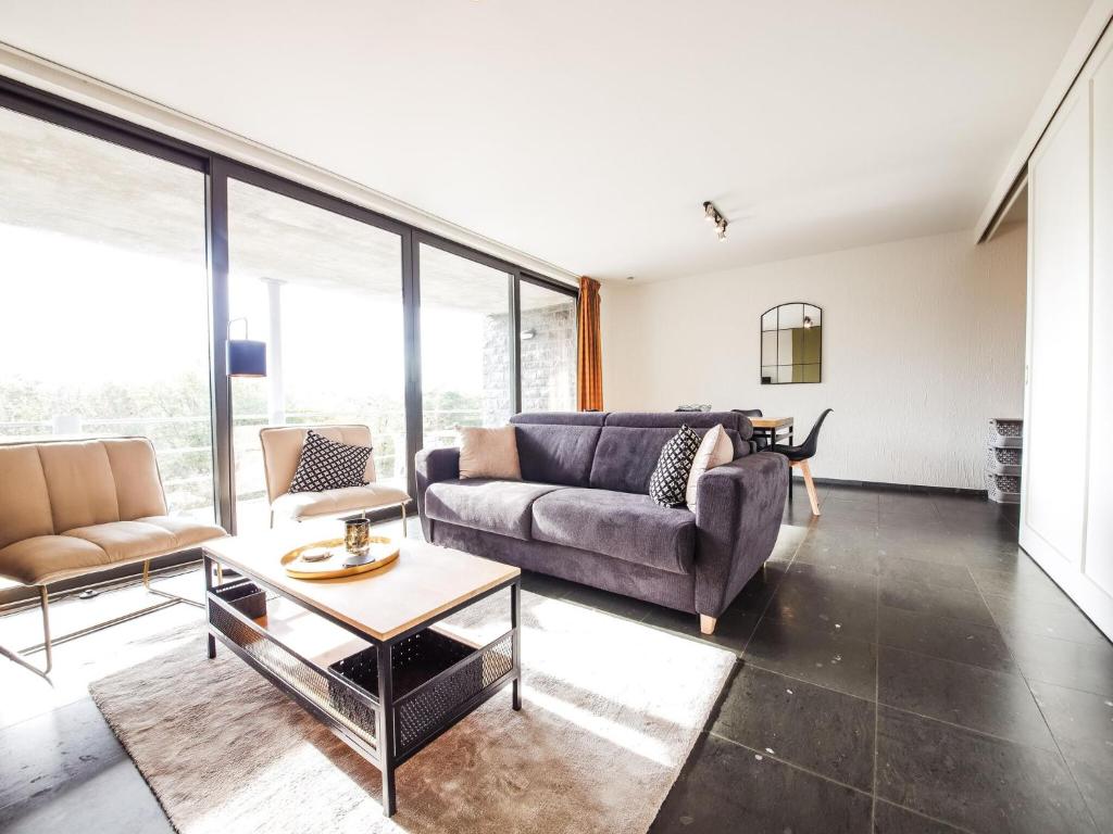 sala de estar con sofá y mesa en Apartment Château Castelnau on a golf course in Durbuy, en Barvaux