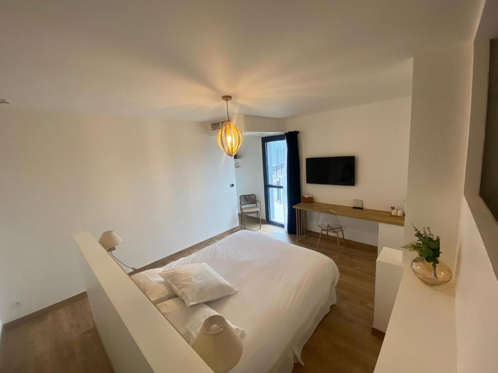 a white bedroom with a bed and a desk at LA TOUR AUX CRABES près de la plage in Dieppe