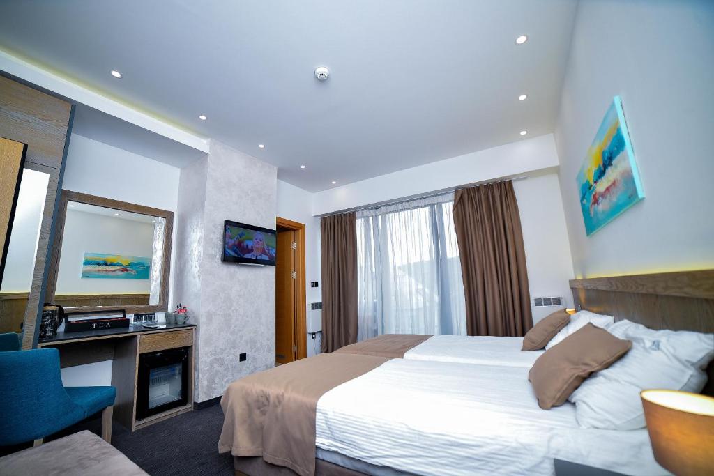 a hotel room with a bed and a television at Apartman Milinović Zlatibor - Hotel Alibi in Zlatibor
