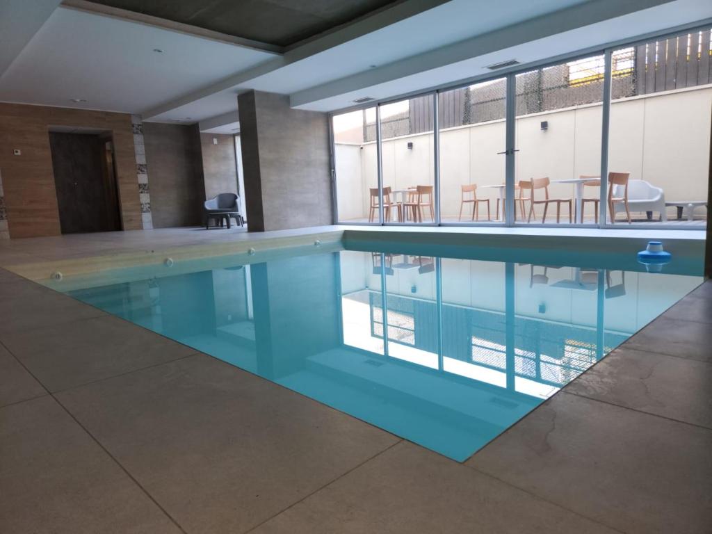 a swimming pool with blue water in a building at Gran Hotel Dakar in Mendoza