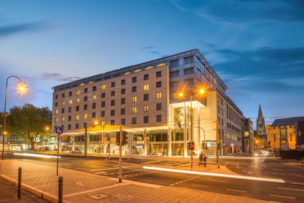 un edificio en una calle de la ciudad por la noche en Dorint Hotel am Heumarkt Köln, en Colonia