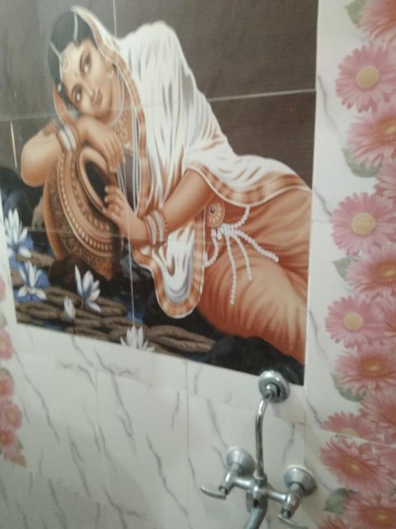 a painting of a woman on a wall in a bathroom at Rks Homestay in Hampi