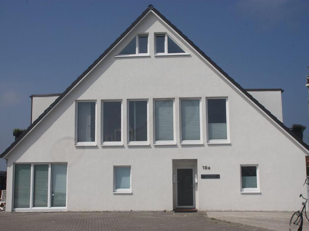 une maison blanche avec un toit en gambrel dans l'établissement Hafenloft App 1, à Norderney