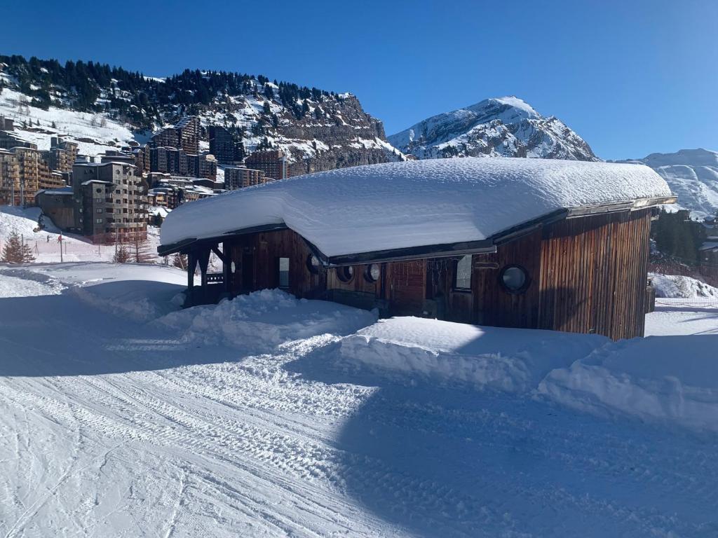 Luxury Avoriaz Chalet with hot tub في أفورياز: مبنى مغطى بالثلج بجوار طريق