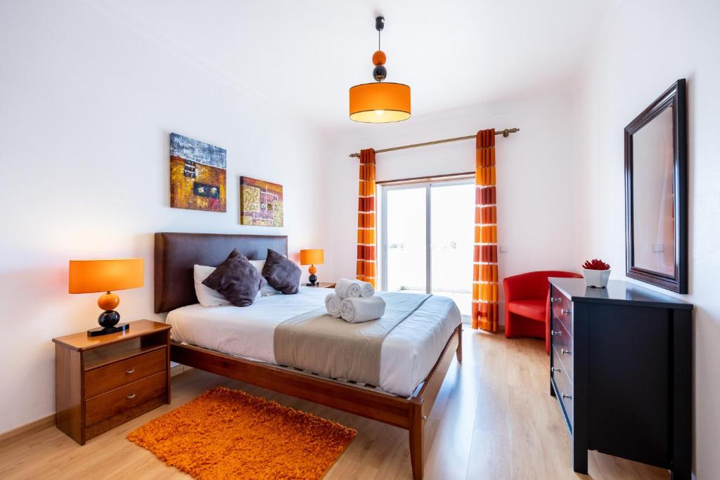 Un dormitorio con una cama con una cómoda y un televisor. en IM On House of Organa, en Lagos
