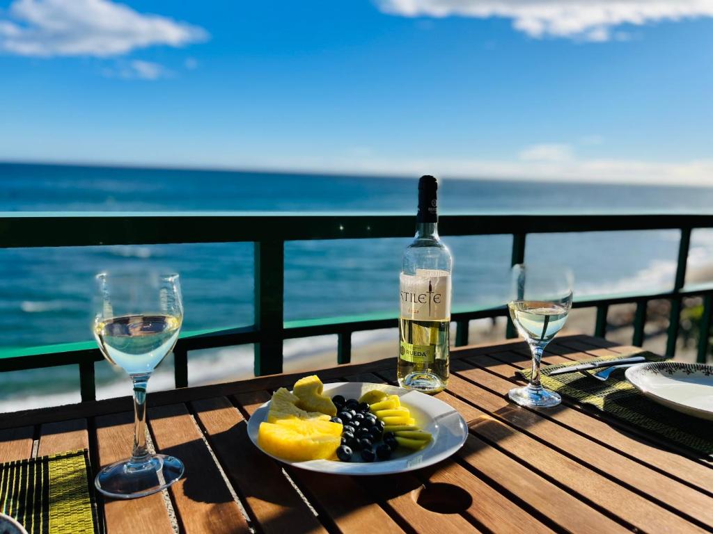 una mesa con una botella de vino y un plato de fruta en MagicViews by gms apartamentos en Fuengirola