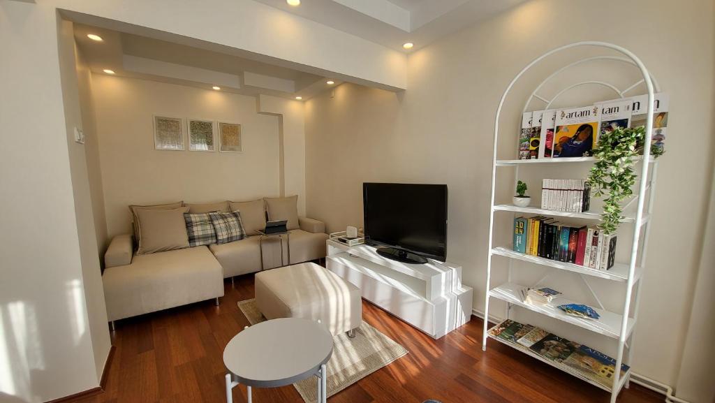 sala de estar con sofá y TV en Flat with Bosphorus view in Rumelihisarı en Estambul