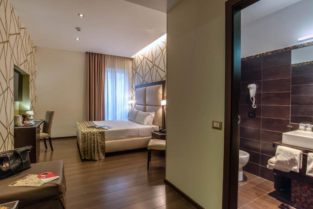 a hotel room with a bed and a bathroom at Catone District Hotel in Rome