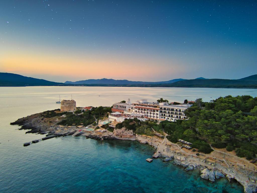 een luchtzicht op een resort op een eiland in het water bij El Faro Hotel & Spa in Porto Conte