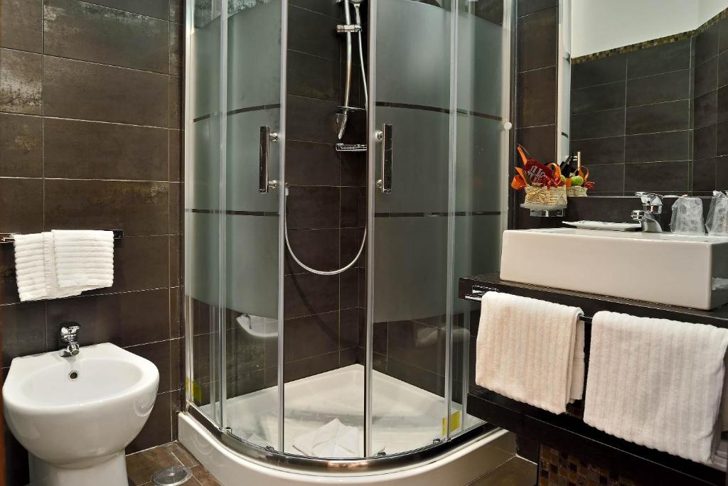 a bathroom with a shower and a toilet and a sink at Catone District Hotel in Rome
