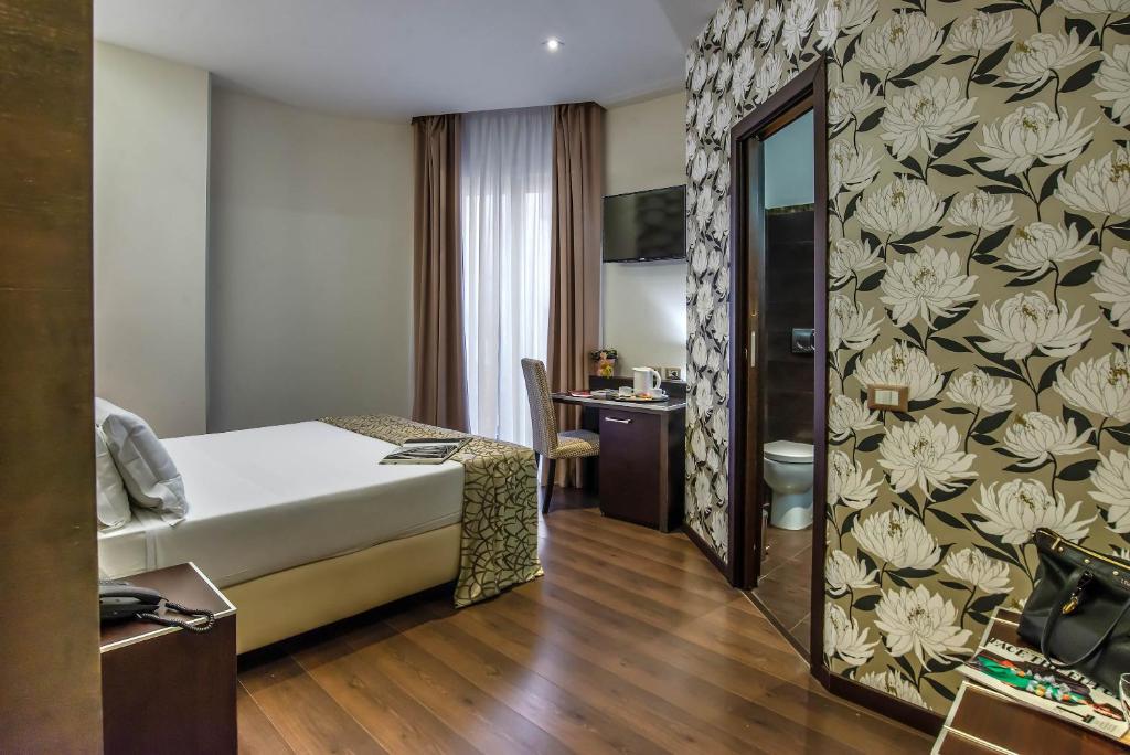 a hotel room with a bed and a bathroom at Catone District Hotel in Rome