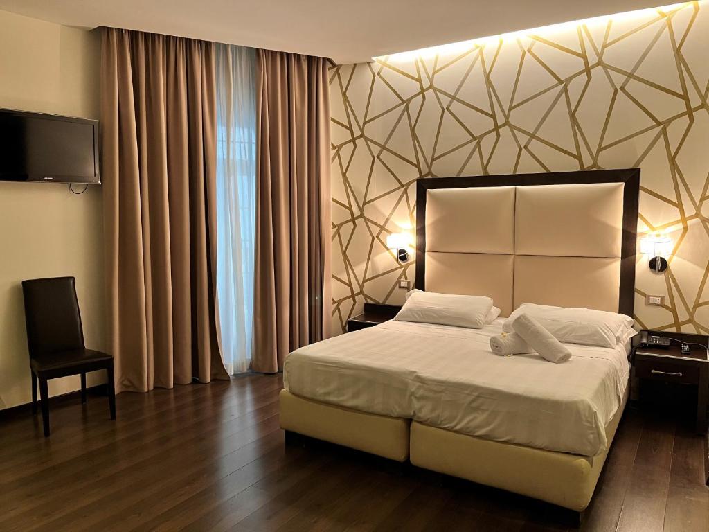 1 dormitorio con 1 cama grande y TV en Catone District Hotel, en Roma