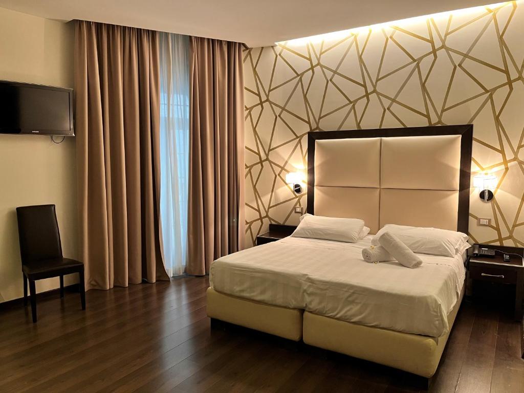 a bedroom with a large bed and a television at Catone District Hotel in Rome
