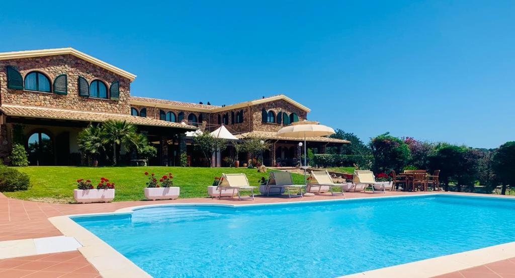 una casa con piscina di fronte a una casa di Hotel Janas a Tertenìa
