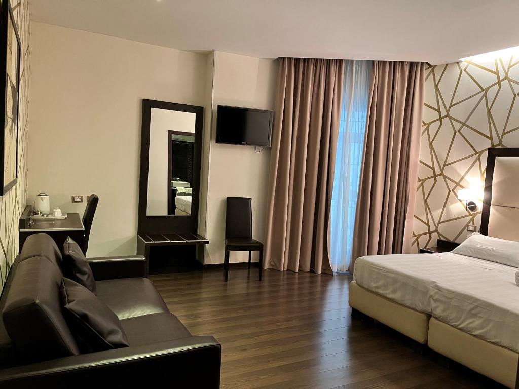 a hotel room with a bed and a couch at Catone District Hotel in Rome