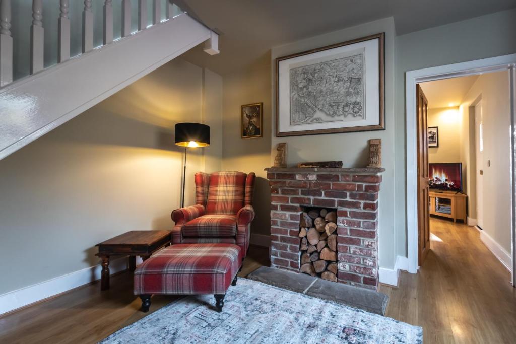 a living room with a chair and a brick fireplace at Rustic cabin located in a serene forest setting in Southampton