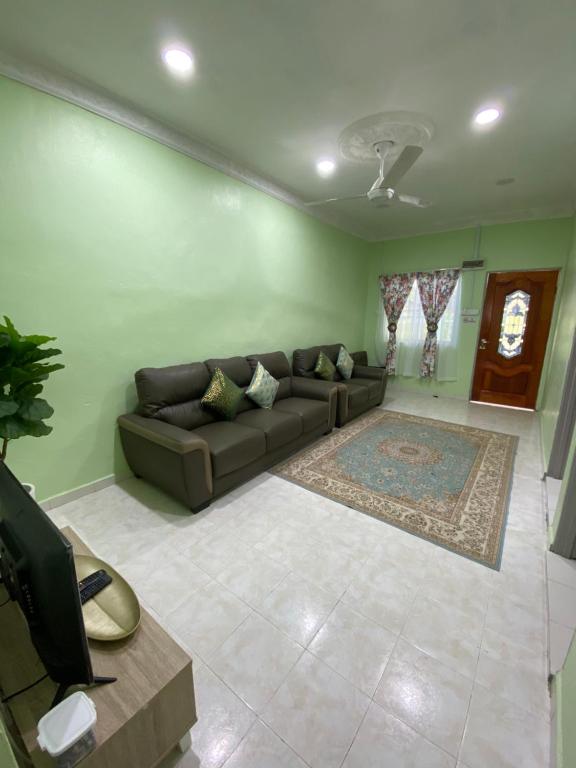 ein Wohnzimmer mit einem Sofa und einem Teppich in der Unterkunft Green Home Homestay Melaka in Masjid Tanah