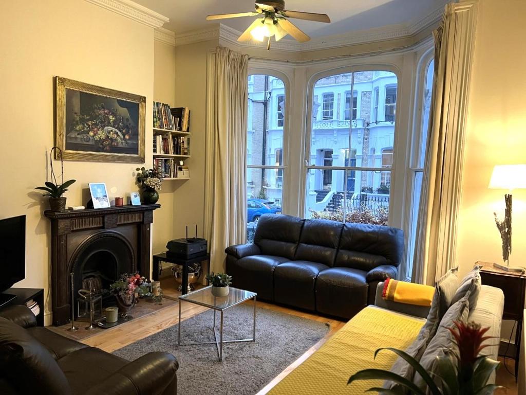 sala de estar con sofá y chimenea en Double bedroom with en-suite bathroom in Chelsea - central London - share apartment en Londres