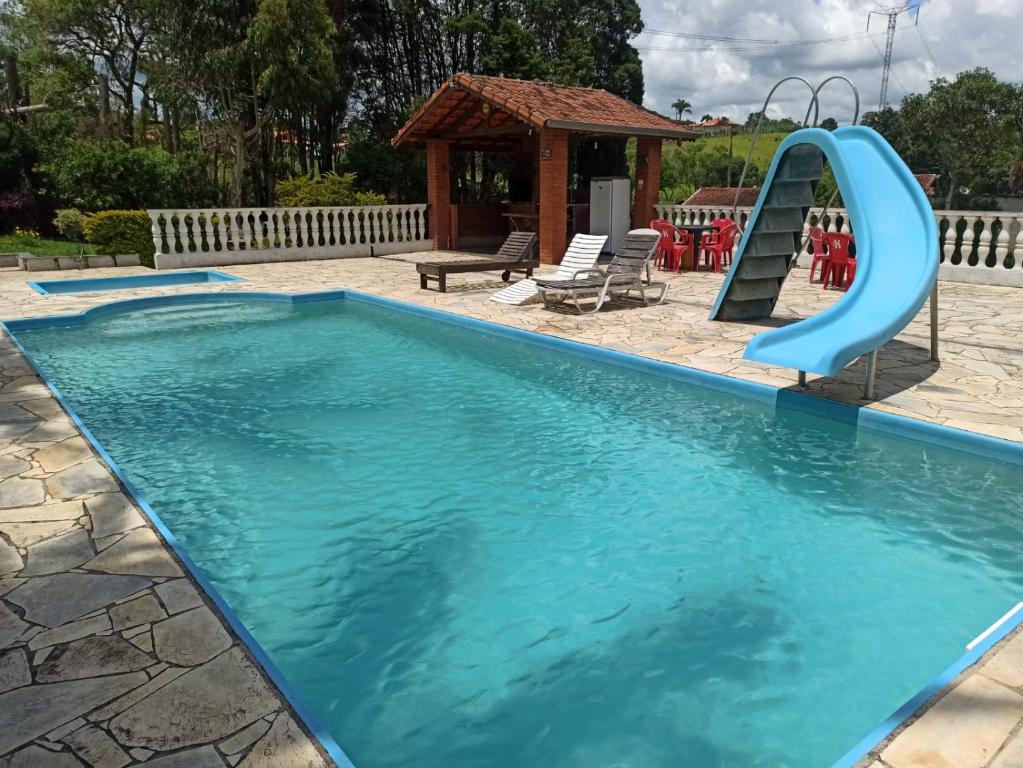 a swimming pool with a slide in a playground at Chácara em Ibiúna São Roque a 70km de SP com piscina e wi-fi in Ibiúna