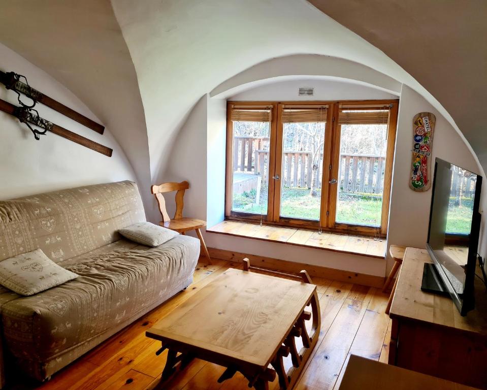una sala de estar con un sofá y una mesa en Le Préau, en Ornon