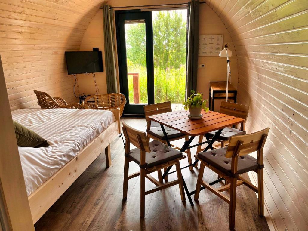 een kamer met een bed en een tafel en stoelen bij Pod Hotelkamer aan het water in Dokkum