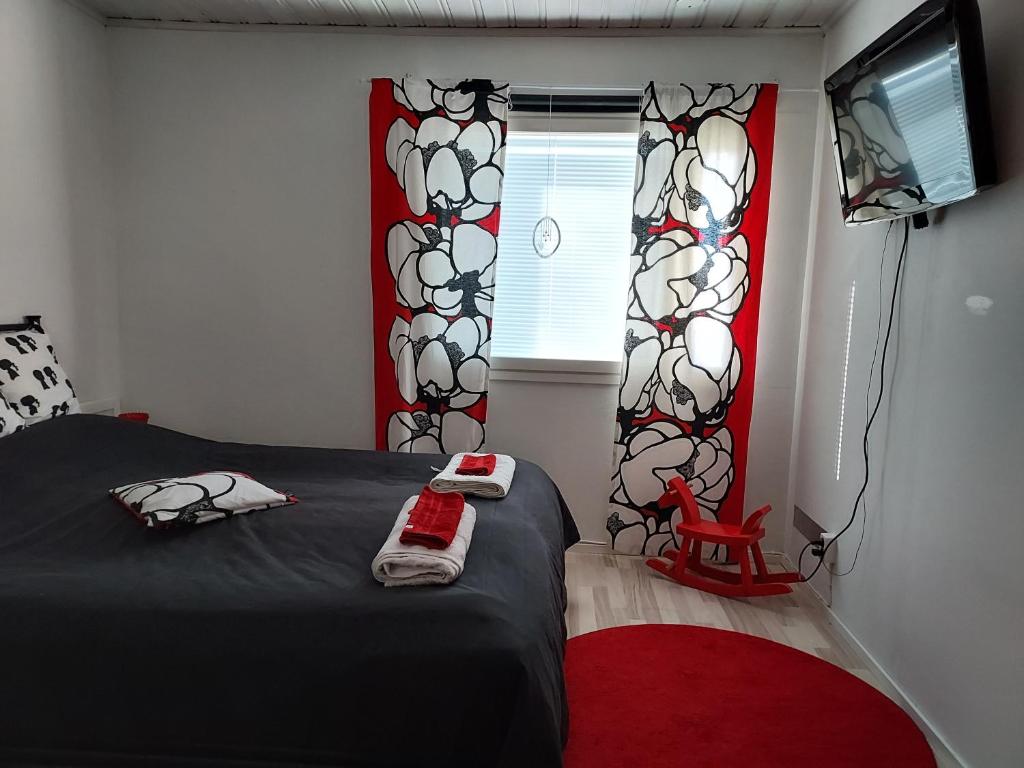 una camera con un letto nero e un tappeto rosso di Apartment Tallitalo - Garage House a Nakkila