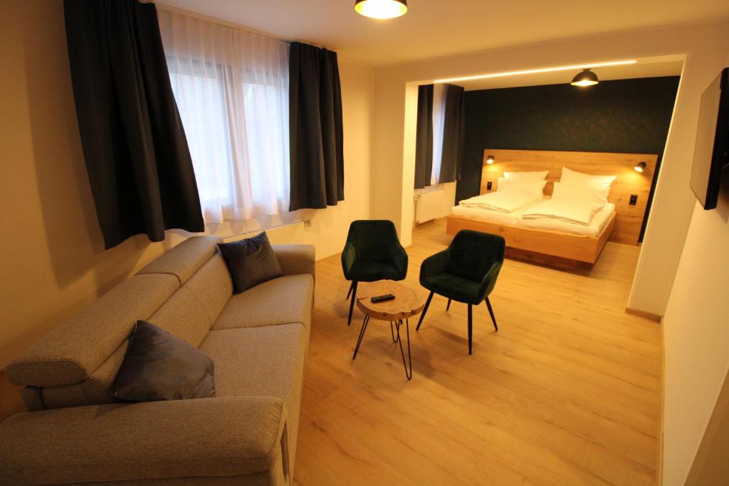 DER Hirsch Hotel في مونشاو: غرفة معيشة مع أريكة وسرير