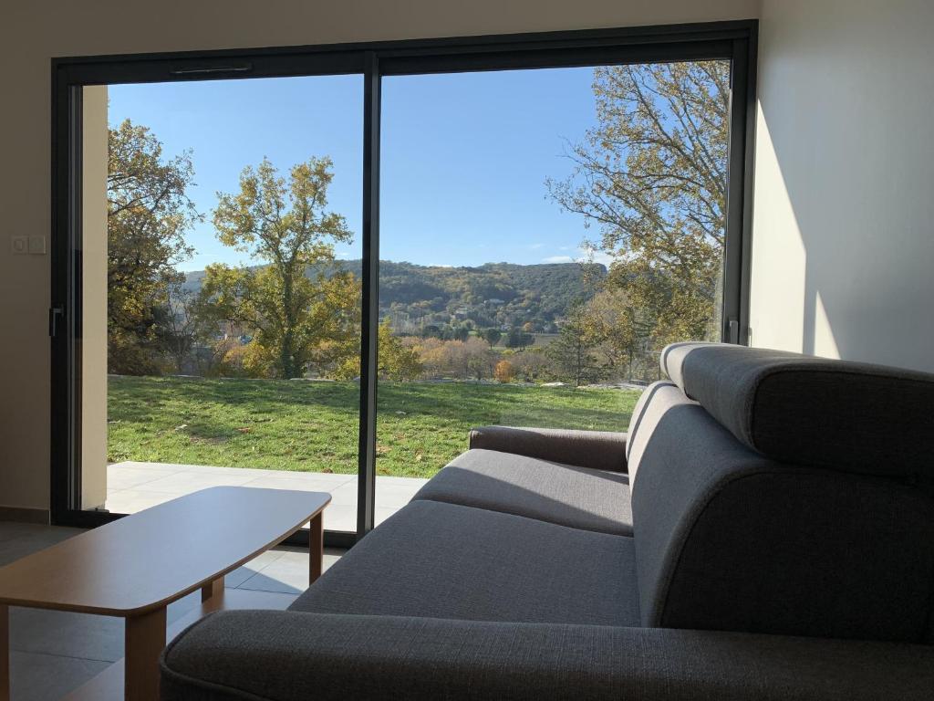 a living room with two couches and a large window at ENTRE RIVIERE ET FORET in Vallon-Pont-dʼArc