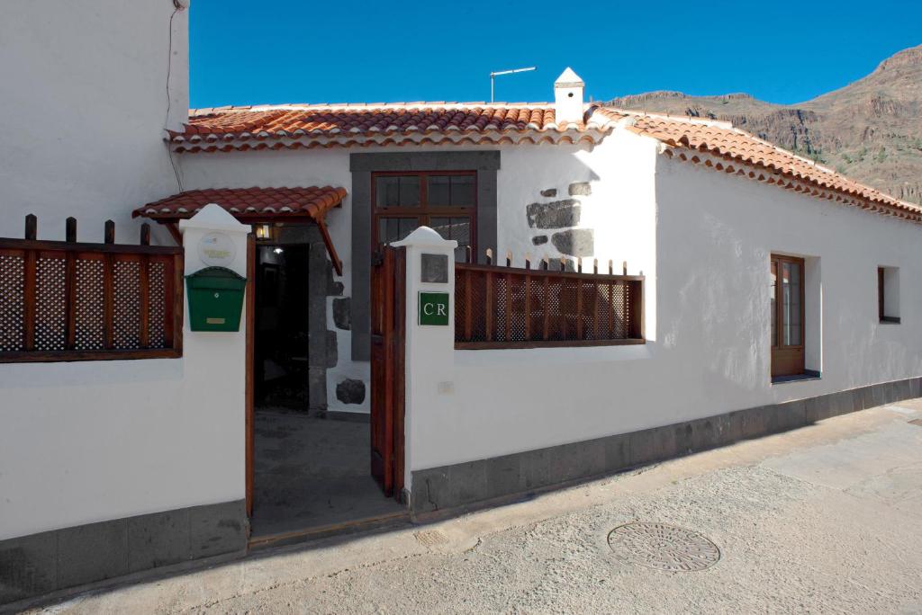 a white house with a gate and a fence at Casa De La Eterna Primavera in San Bartolomé de Tirajana