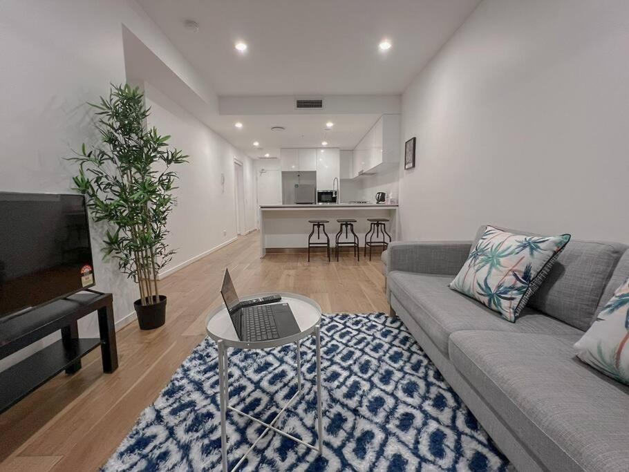 a living room with a couch and a table with a laptop at 1.5BR apartment Fortitude Valley in Brisbane
