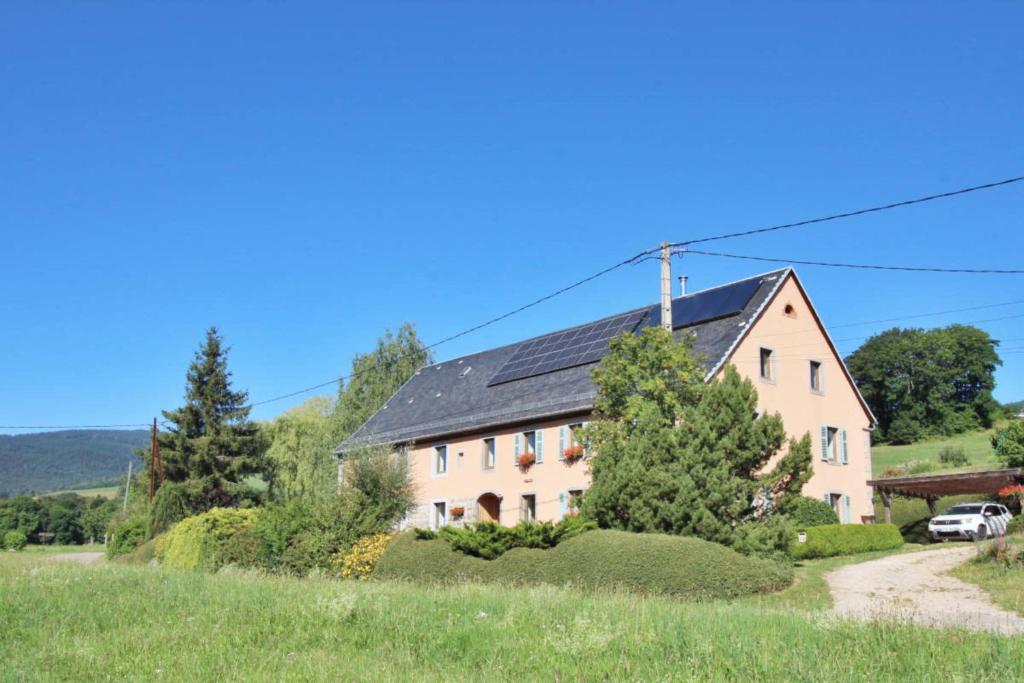 una grande casa bianca con tetto nero di Gîte Les 4 Saisons a Orbey