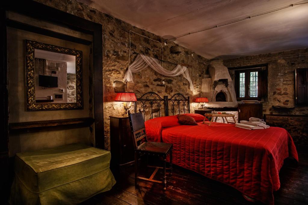 a bedroom with a red bed and a chair at La Voce del Fiume Dimora di Charme in Brienza