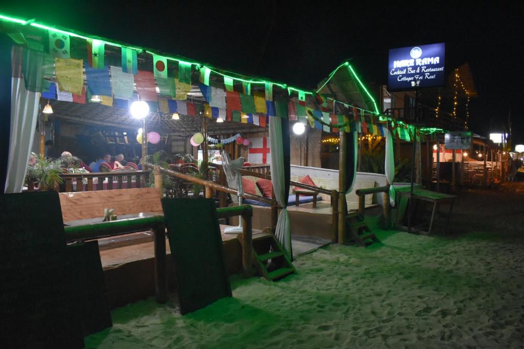 a restaurant with flags and a bar at night at Hare's BAR AND RESTAURANT in Canacona
