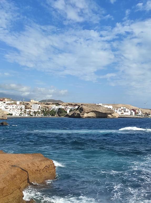 Playa Celeste Tajao في La Mareta: اطلاله على تجمع مياه مع مباني في الخلف