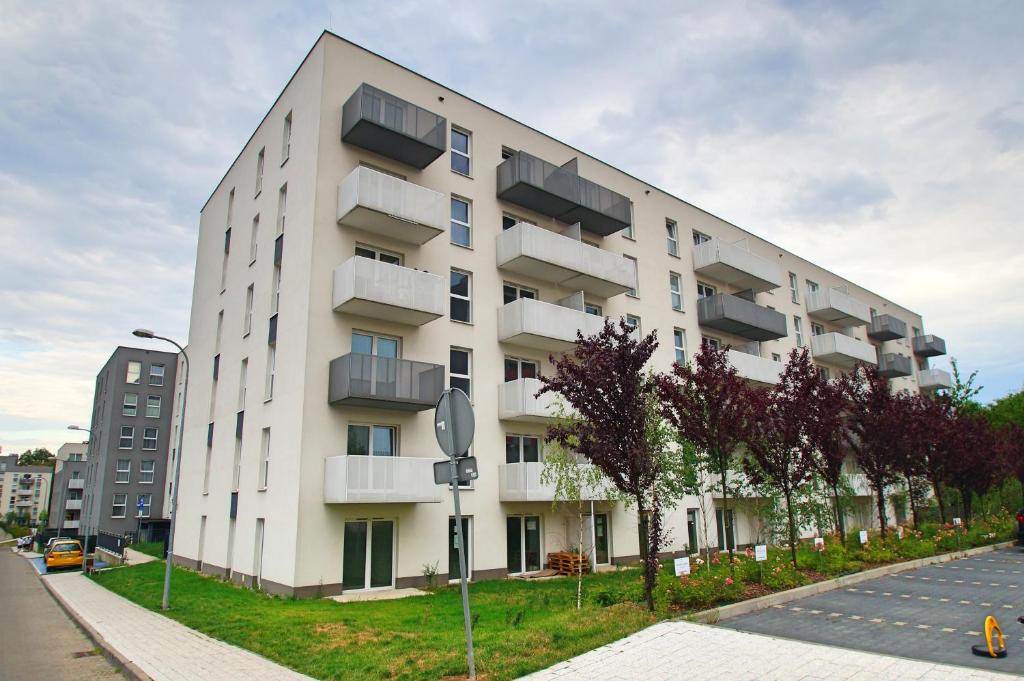 a white building with balconies on the side of a street at Apartament Bytkowska in Katowice