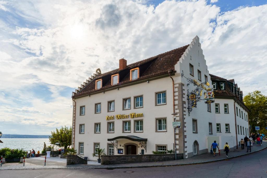 un gran edificio blanco al lado de una calle en Hotel Wilder Mann en Meersburg