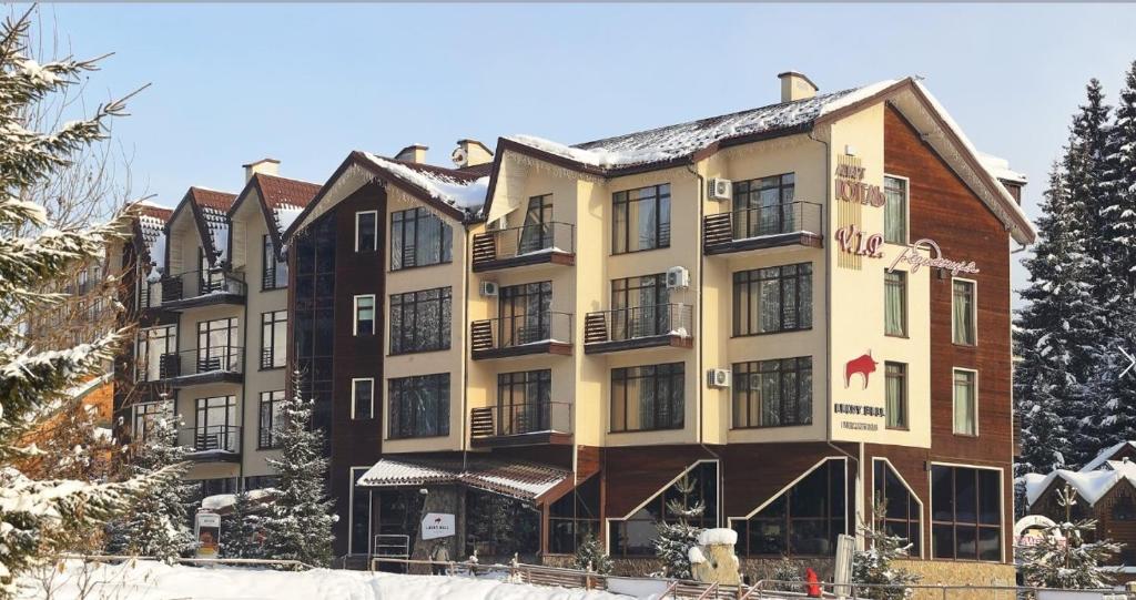 Bukovel Apart في بوكوفِل: فندق في الشتاء مع ثلج على الارض
