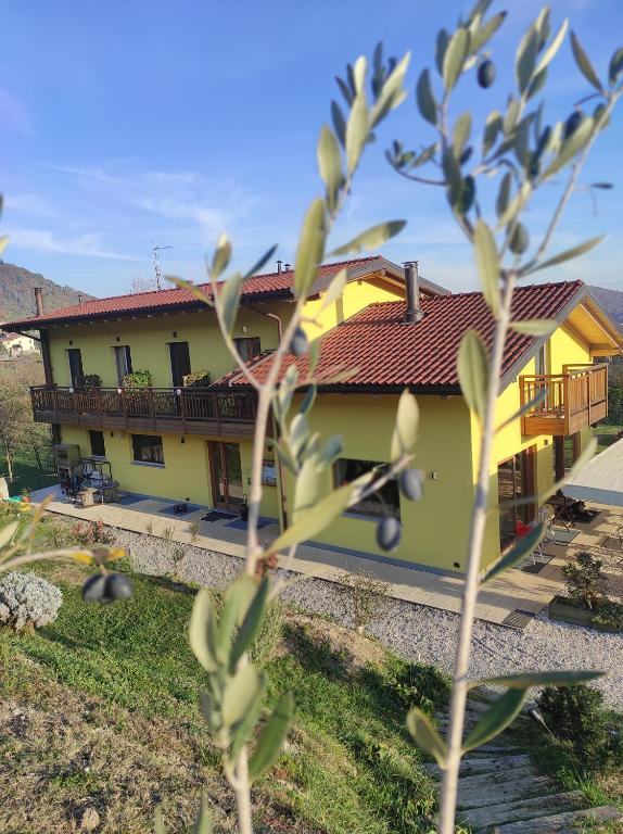 una casa amarilla con techo rojo en Agriturismo La Soglia Del Parco, en Ranica