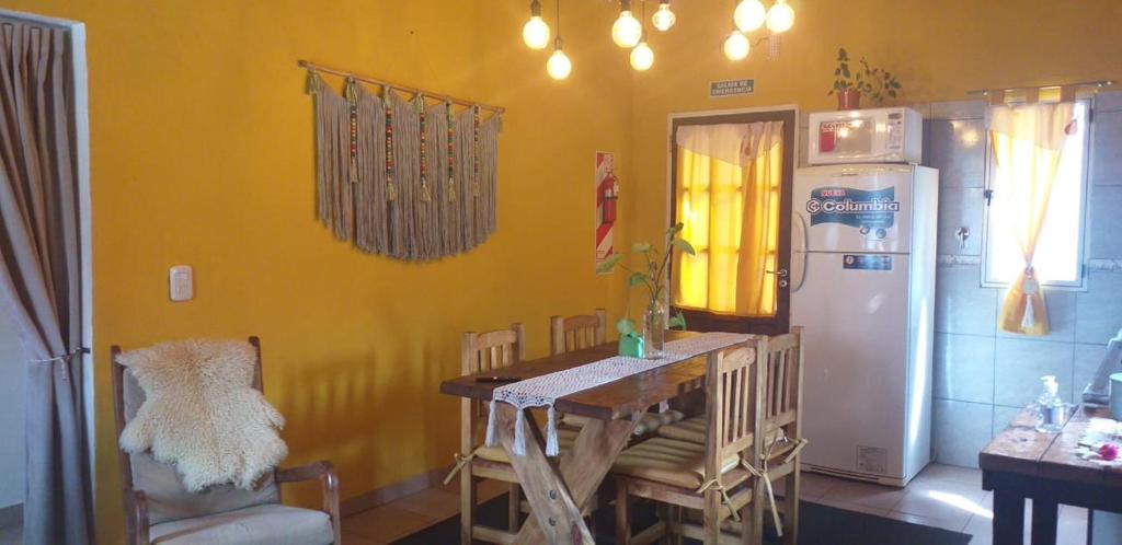 eine Küche mit einem Tisch und einem Kühlschrank in der Unterkunft Casa Rural Bella Zaira in El Calafate