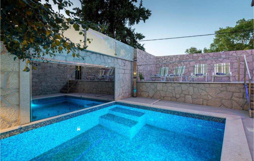 a swimming pool in front of a house at Gorgeous Home In Kamenmost With Kitchen in Kamenmost