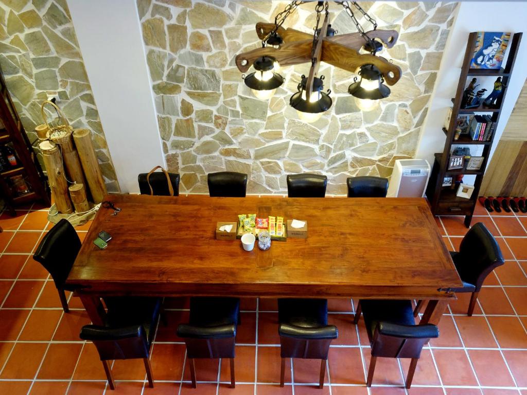 a dining room table with chairs and a chandelier at Shire Homestay in Luodong
