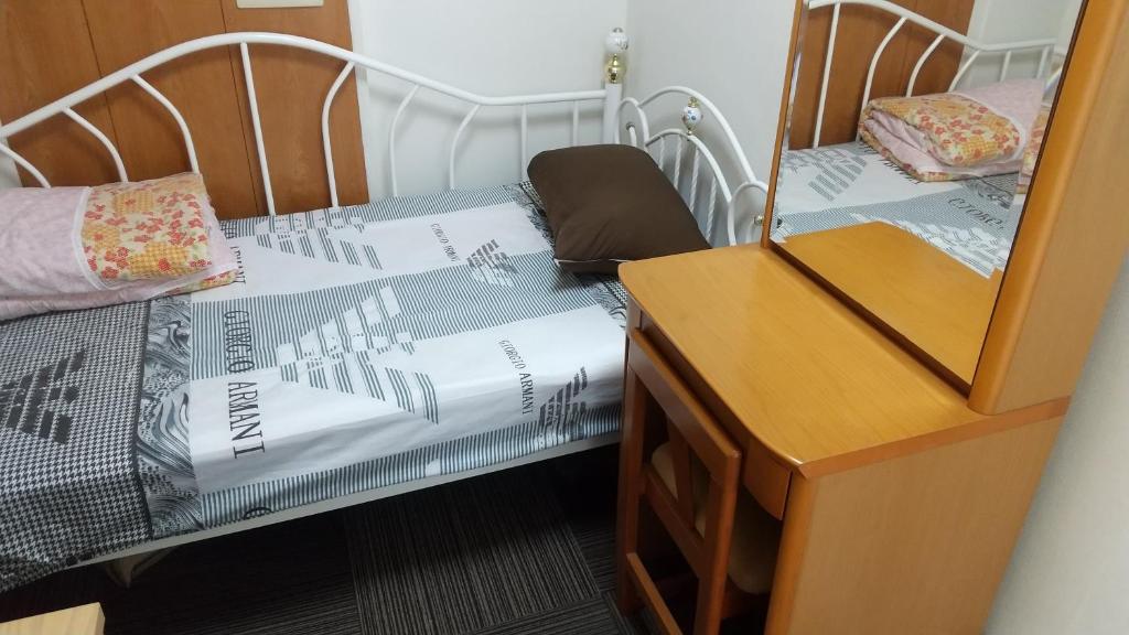 um quarto com uma cama e uma cómoda com um espelho em Minshuku Chatamago em Nagasaki