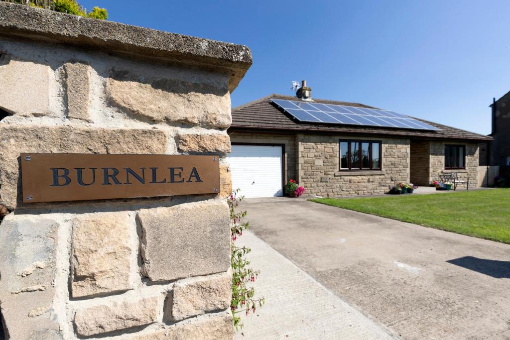 Copley的住宿－H C property - Burnlea Cottage，砖屋,旁边标有标志