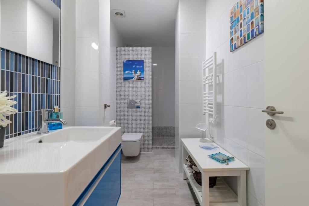 a bathroom with a tub and a toilet and a sink at ApartUP Patacona Azzure in Valencia