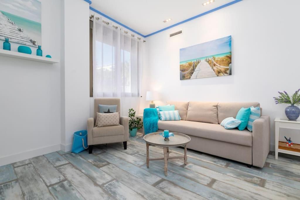 a living room with a couch and a table at ApartUP Patacona Azzure in Valencia