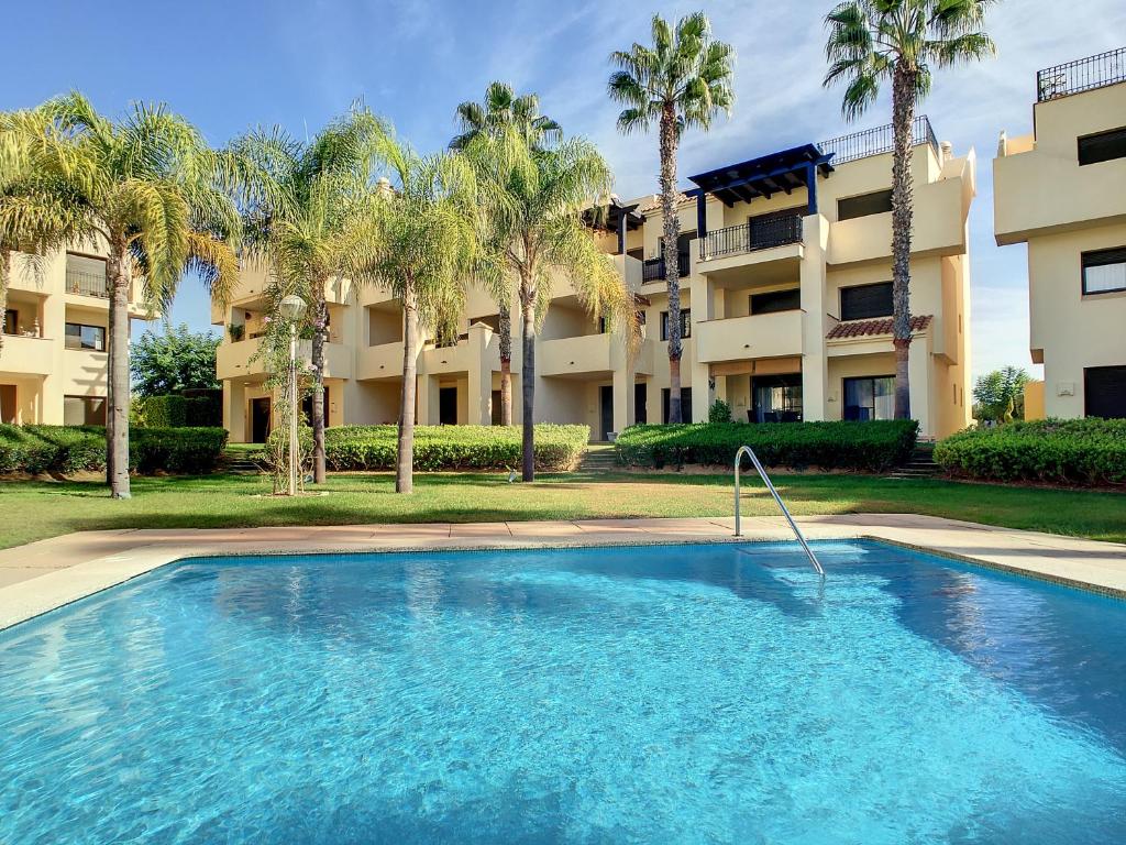 een zwembad voor een gebouw met palmbomen bij Roda Golf Resort - 8809 in San Javier