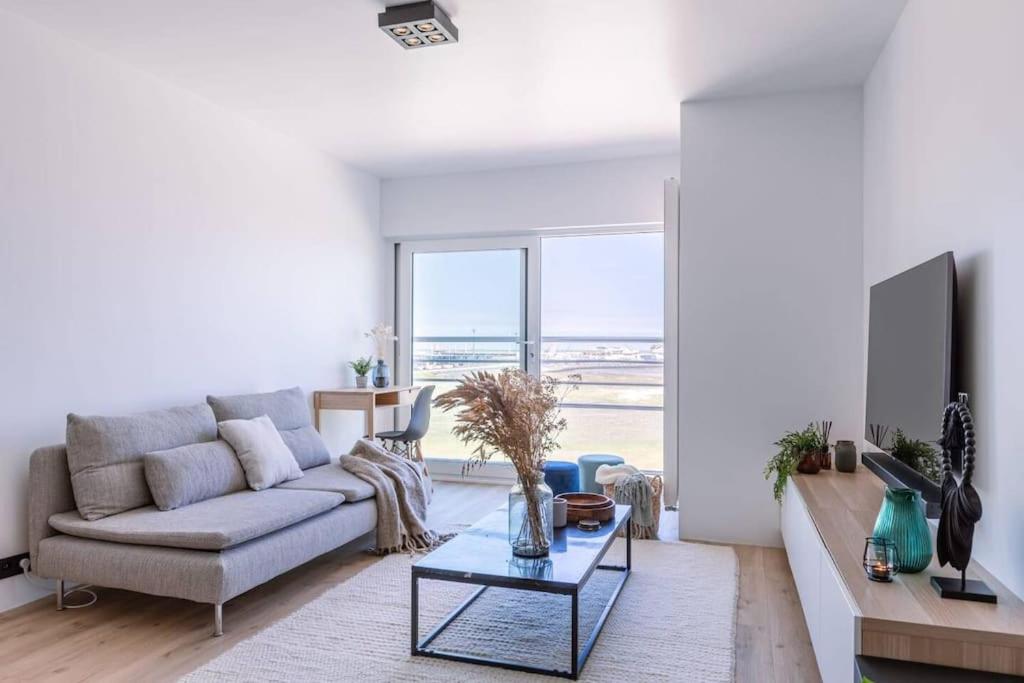 ein Wohnzimmer mit einem Sofa und einem Tisch in der Unterkunft Cozy apartment with beautiful seaview in Knokke-Heist