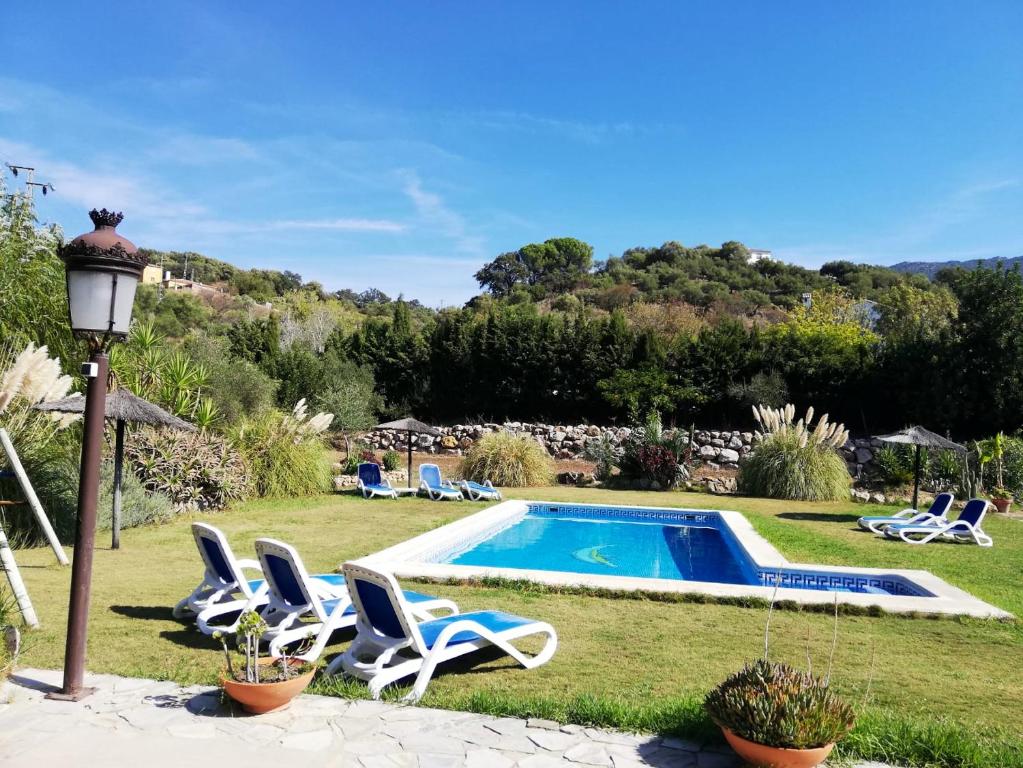uma piscina com espreguiçadeiras e um poste de luz em 5 bedrooms villa with private pool enclosed garden and wifi at Ubriquea em Ubrique